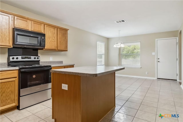 kitchen featuring stainless steel electric range oven, light tile patterned floors, black microwave, a center island, and visible vents