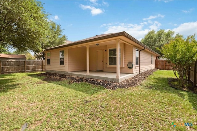 back of house featuring a patio, a yard, and a fenced backyard