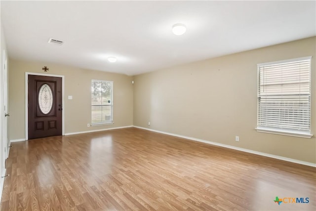 entryway with baseboards, visible vents, and light wood-style flooring