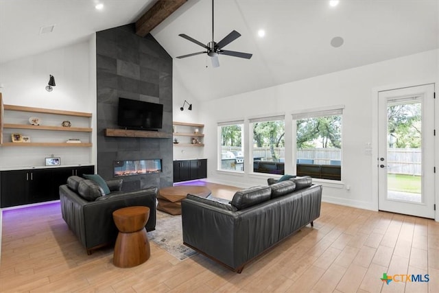 813 Eagle Heights Dr, Salado, TX 76571 - living area featuring high vaulted ceiling, a tile fireplace, healthy amount of natural light, light wood-style floors, and beam ceiling