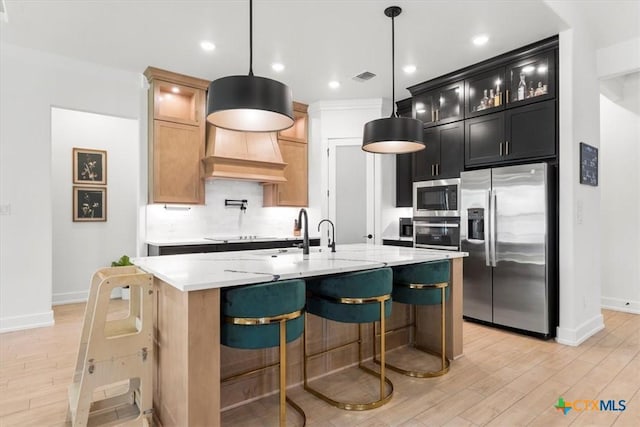813 Eagle Heights Dr, Salado, TX 76571 - kitchen featuring appliances with stainless steel finishes, baseboards, light wood-style flooring, a center island with sink, and recessed lighting