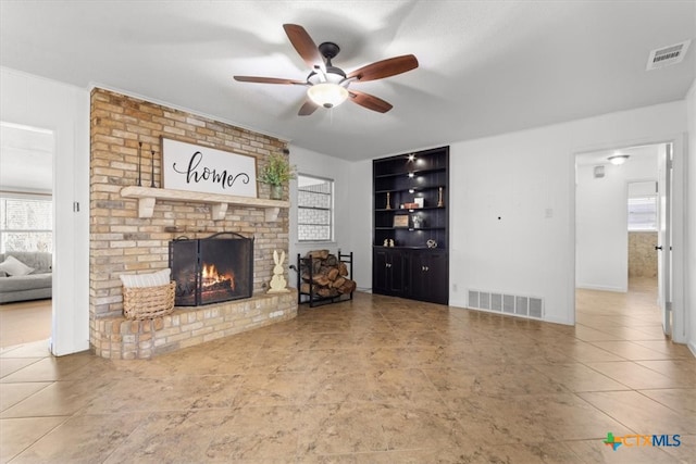 unfurnished living room featuring visible vents, ceiling fan, and a fireplace