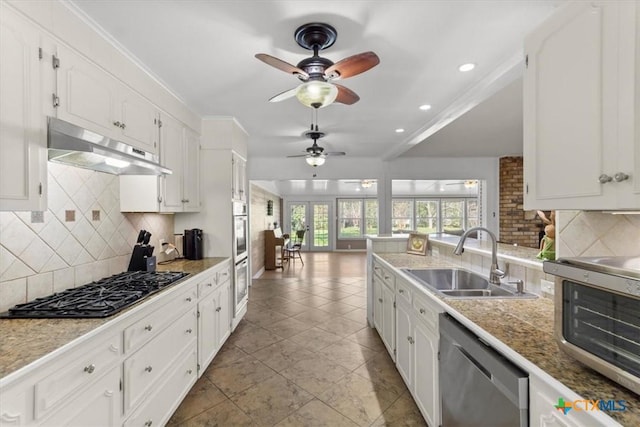 kitchen featuring under cabinet range hood, appliances with stainless steel finishes, white cabinets, a ceiling fan, and a sink