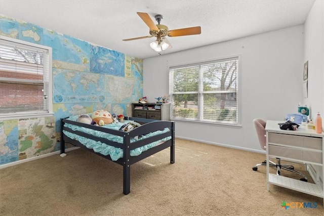 carpeted bedroom featuring wallpapered walls, a ceiling fan, and baseboards