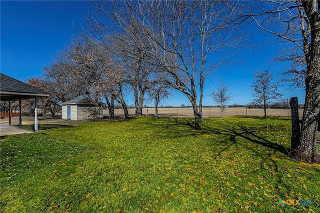 view of yard with a rural view and a shed