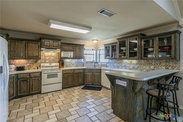 kitchen featuring sink, tasteful backsplash, ornamental molding, kitchen peninsula, and white appliances