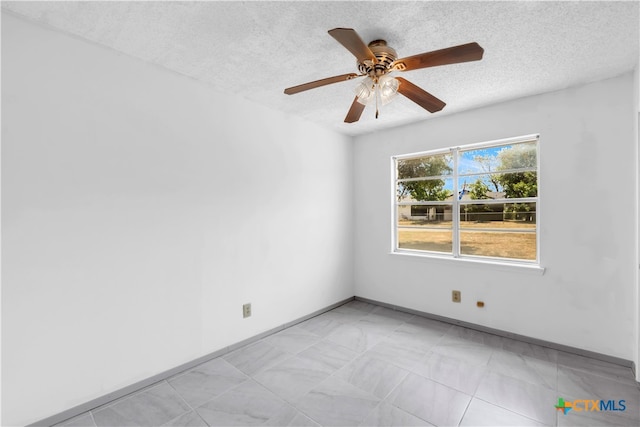 empty room with a textured ceiling and ceiling fan