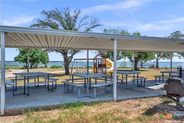 surrounding community with a playground, a yard, a water view, and a patio area