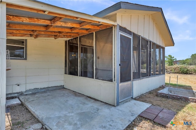 view of property exterior featuring a sunroom and a patio area