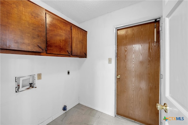 laundry area featuring a textured ceiling, hookup for a washing machine, cabinets, and electric dryer hookup