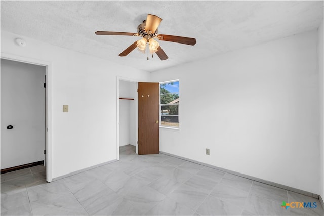 unfurnished bedroom with a textured ceiling, ceiling fan, and a closet