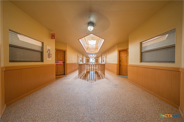 additional living space with wood walls, light carpet, and ceiling fan