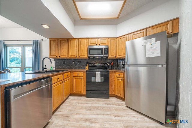 401 W Lincoln St Unit A201, New Braunfels, TX 78130 - kitchen with stainless steel appliances, a sink, decorative backsplash, light wood finished floors, and brown cabinetry