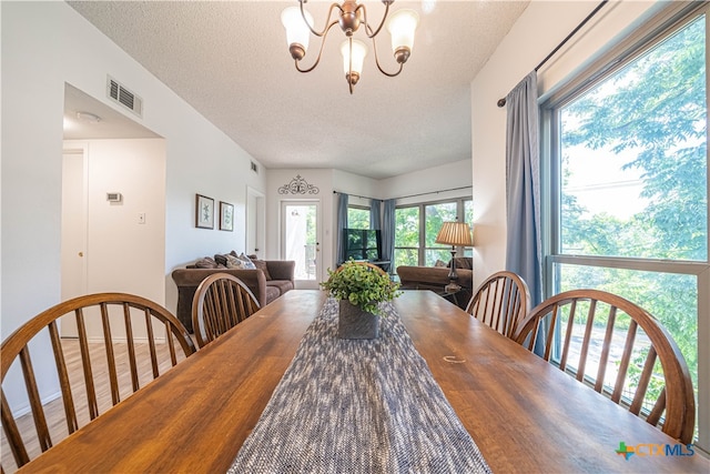 dining room with a chandelier and a textured ceiling