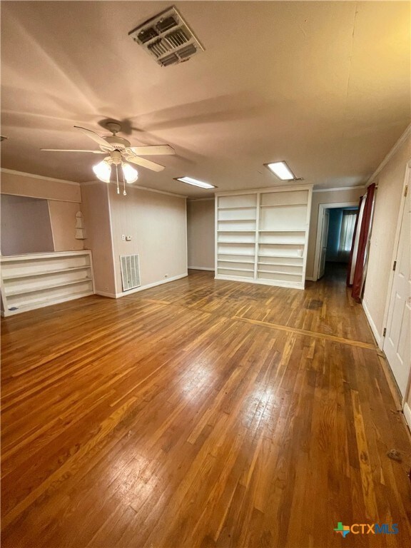 interior space featuring dark wood-type flooring and ceiling fan