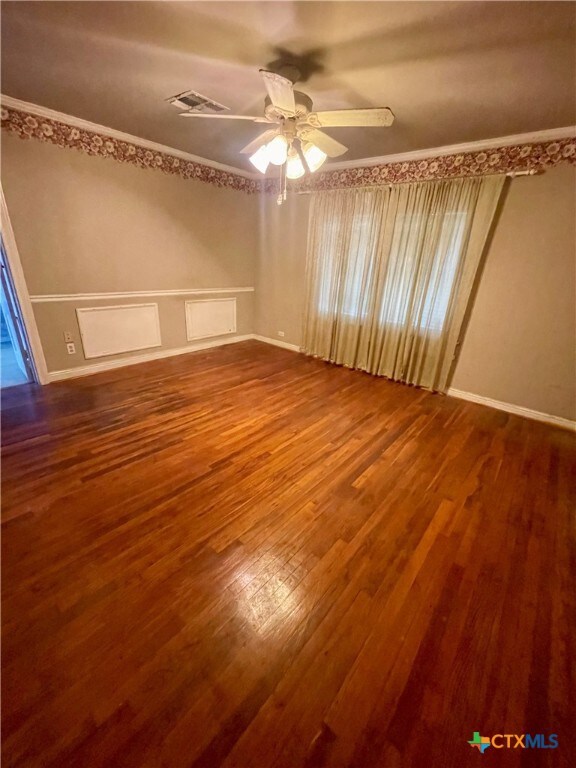 empty room with ornamental molding, hardwood / wood-style flooring, and ceiling fan