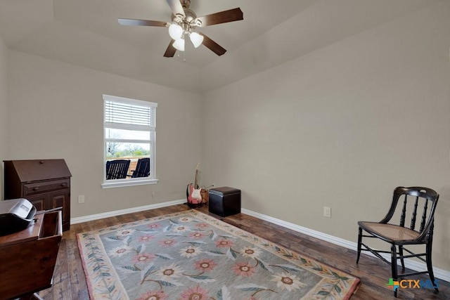 interior space featuring dark hardwood / wood-style flooring, a raised ceiling, and ceiling fan