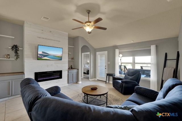 living room with lofted ceiling, light tile patterned floors, built in features, and a fireplace