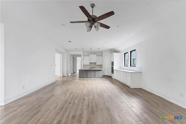 unfurnished living room featuring recessed lighting, a ceiling fan, baseboards, and light wood finished floors