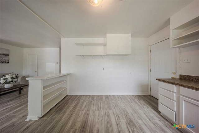 2613 Goliad St, Temple, TX 76501 - kitchen with open shelves, light wood-type flooring, white cabinets, and baseboards