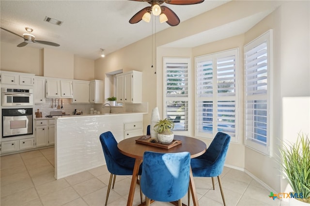 tiled dining room featuring a textured ceiling and ceiling fan