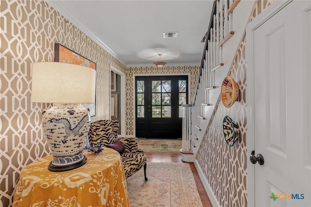 doorway to outside featuring wood-type flooring and ornamental molding