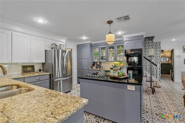 kitchen with double oven, sink, gray cabinets, stainless steel refrigerator, and hanging light fixtures