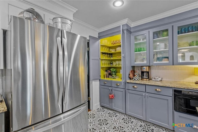 kitchen with oven, light stone counters, crown molding, and stainless steel refrigerator