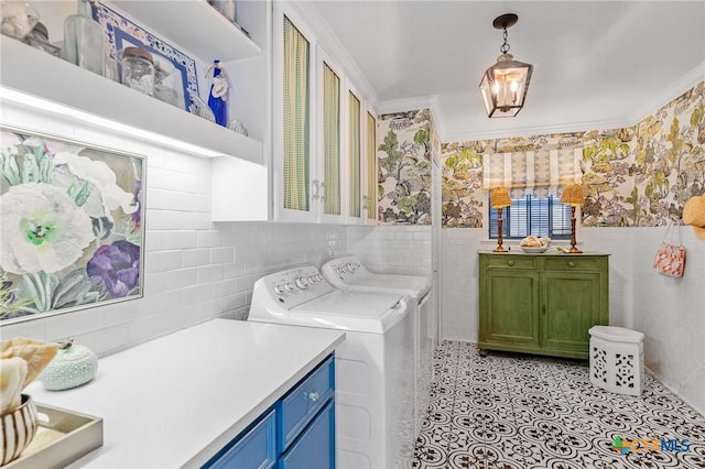 washroom with cabinets, washer and dryer, ornamental molding, and tile walls