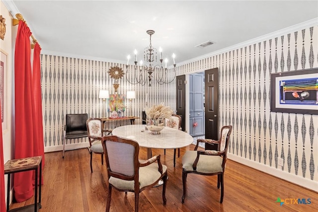 dining room featuring a chandelier, wood-type flooring, and crown molding