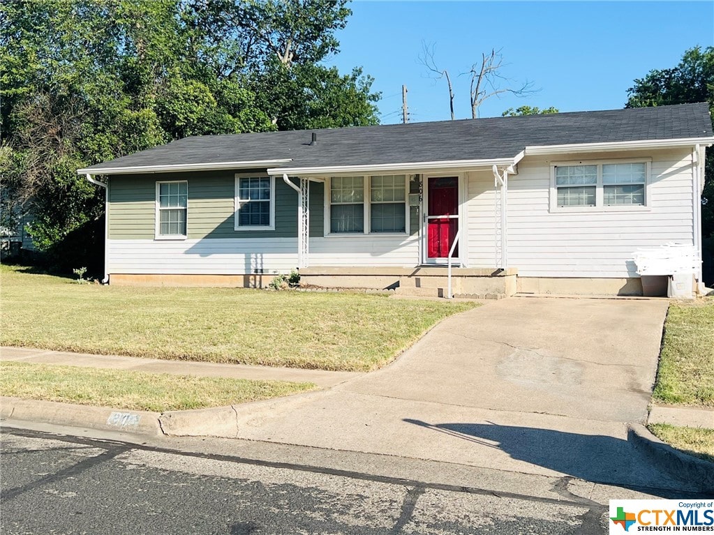 ranch-style home with covered porch and a front lawn