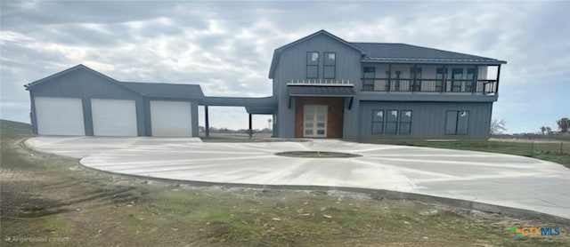 view of front facade featuring a balcony, an outdoor structure, and a garage