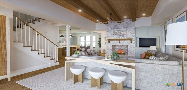 living room with beamed ceiling, a fireplace, wood ceiling, and hardwood / wood-style floors