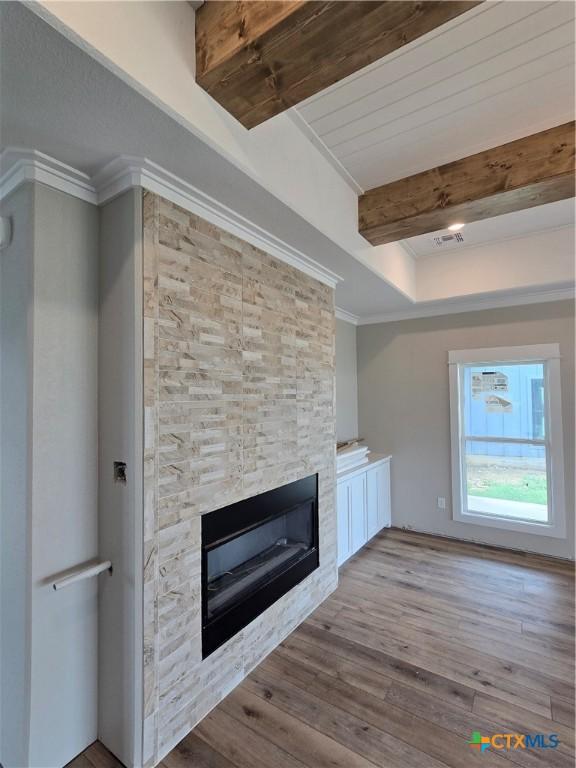 8186 S Lone Star Pkwy, Moody, TX 76657 - unfurnished living room with a fireplace, ornamental molding, wood finished floors, and beam ceiling