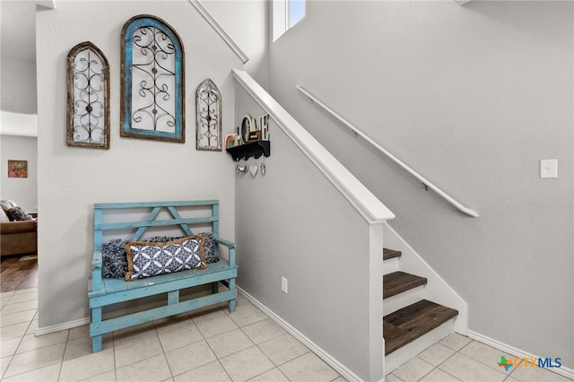 stairs featuring baseboards and tile patterned floors