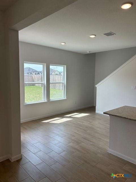 spare room featuring recessed lighting, wood finished floors, visible vents, and baseboards