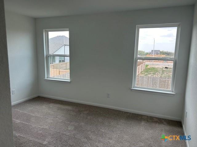 empty room featuring baseboards and carpet floors