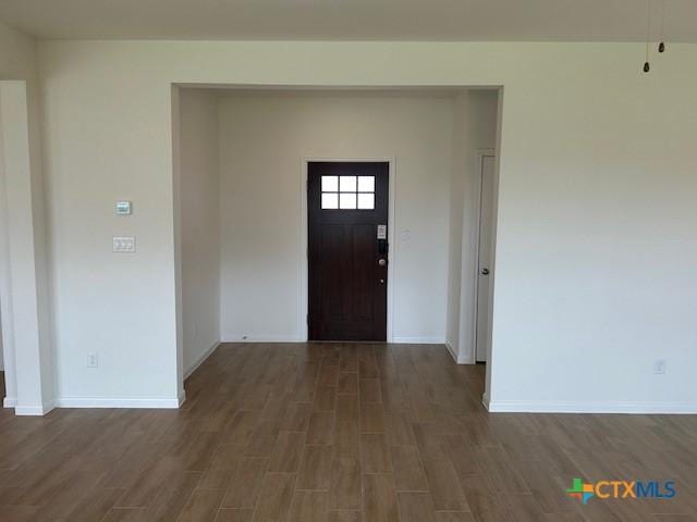entryway featuring baseboards and wood finished floors