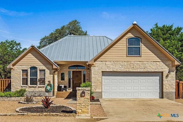 10 Long Bow Ln, Wimberley, TX 78676 - view of front facade with stone siding, driveway, a garage, and a metal roof