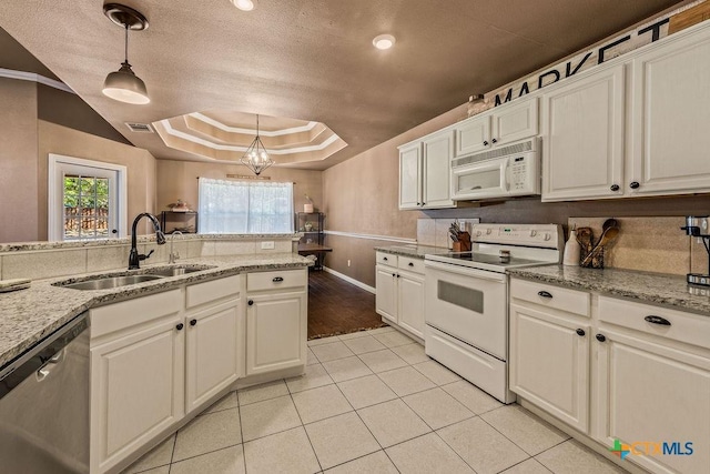 10 Long Bow Ln, Wimberley, TX 78676 - kitchen featuring white appliances, a tray ceiling, decorative light fixtures, white cabinetry, and a textured ceiling