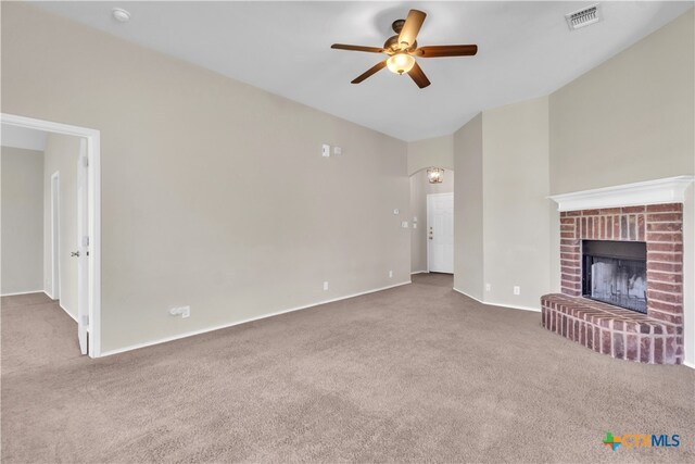 unfurnished living room featuring a fireplace, ceiling fan, and carpet floors