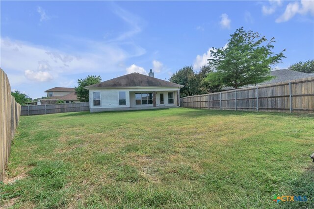 rear view of house featuring a lawn