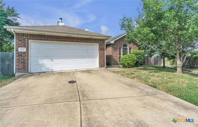 ranch-style home featuring a garage and a front lawn