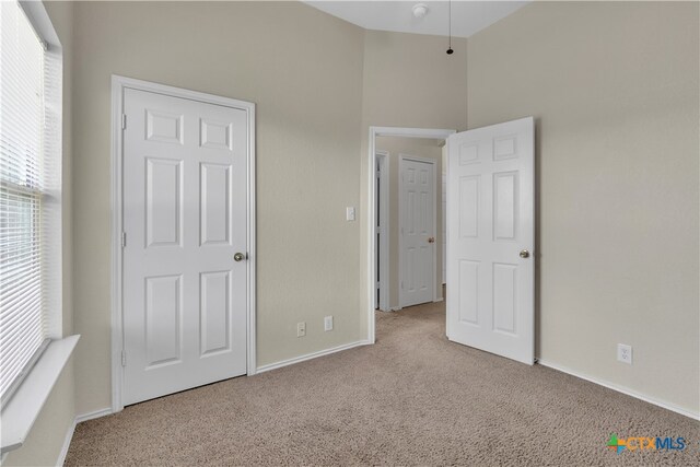 unfurnished bedroom featuring light carpet