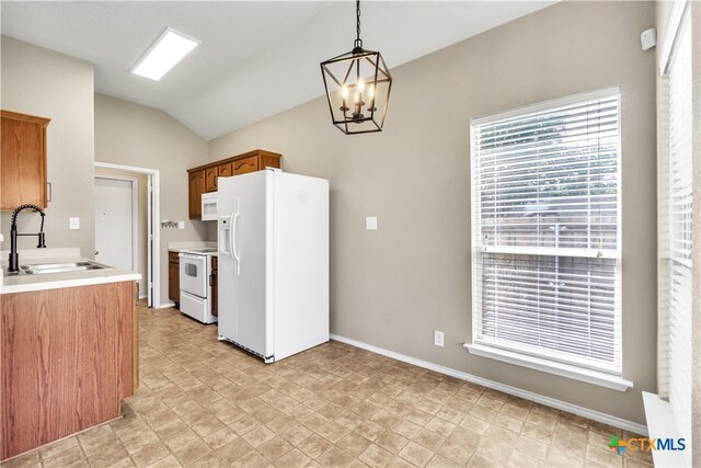 kitchen with sink, an inviting chandelier, hanging light fixtures, white appliances, and lofted ceiling