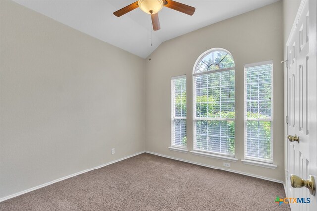 carpeted spare room featuring ceiling fan and vaulted ceiling