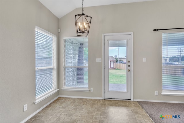 doorway to outside with a wealth of natural light, a chandelier, and vaulted ceiling