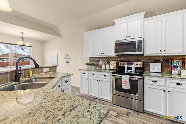 2017 Wagon Gap Rd, Temple, TX 76502 - kitchen featuring a sink, appliances with stainless steel finishes, tasteful backsplash, and an inviting chandelier