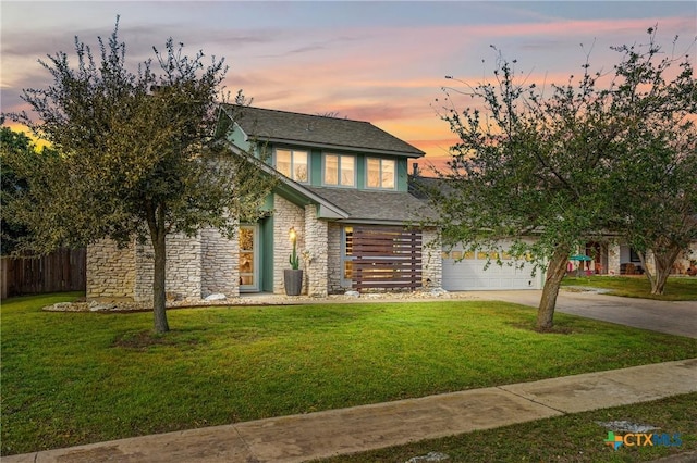 view of front facade featuring stone siding, a front yard, concrete driveway, and fence