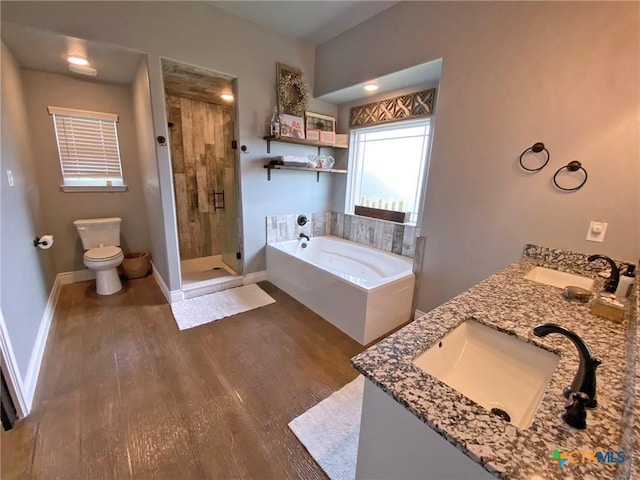 full bath featuring a bath, wood finished floors, a sink, and toilet